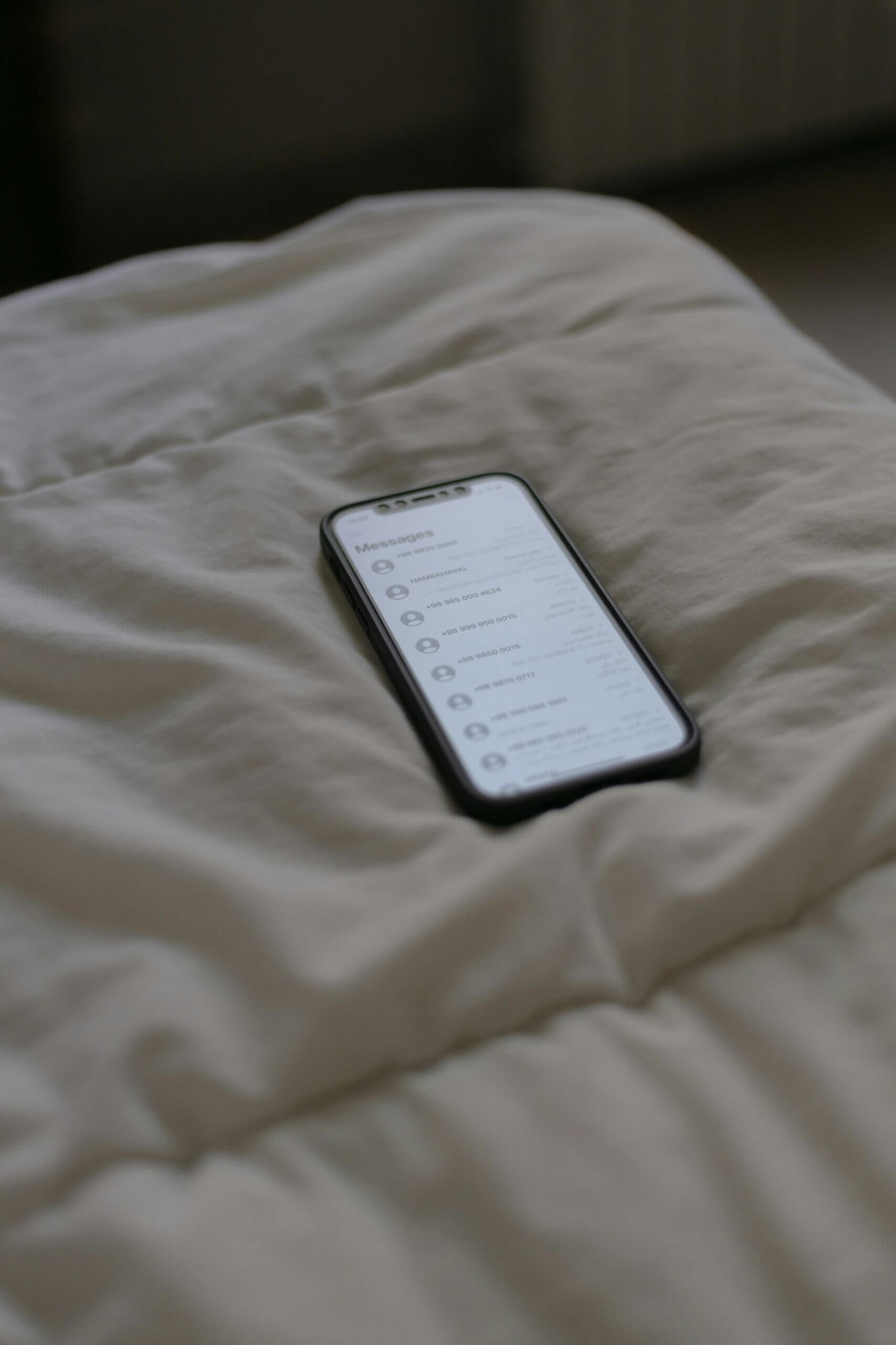 person using phone on bed scaled